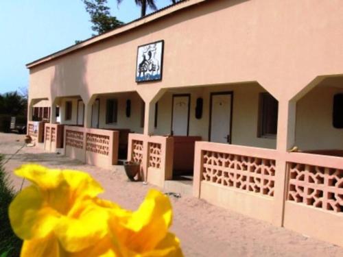 a yellow flower in front of a building at The Gunjur Project Lodge in Gunjur