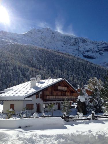 a house in the snow in front of a mountain at Haus Lena in Solda