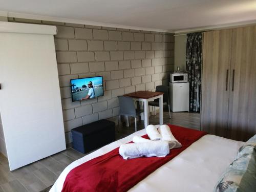 a bedroom with a bed and a tv on a wall at Farm View Guest House in East London