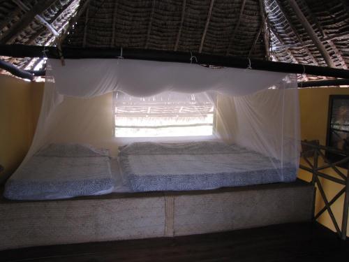 a bed in a room with a window at Kipepeo Beach and Village in Dar es Salaam