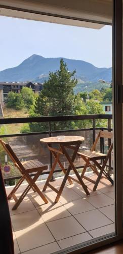 a table and benches on a balcony with a view at Studio au pied des pistes Briançon Serre Chevalier in Briançon