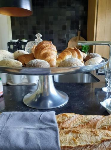 a tray of breads and croissants on a table at LA BELLE IDEE in Nokere