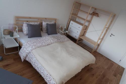 Un dormitorio con una cama con almohadas azules y una escalera en Luxurious apartment 3 min walk to city center - snack, beverages included in price, en Spišská Nová Ves