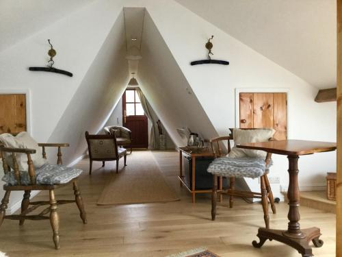a living room with an attic with chairs and a table at Dwynant - A Room with a View in Llangathen