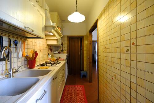a kitchen with a sink and a tile wall at Il Melograno - San Quirico d'Orcia in San Quirico dʼOrcia