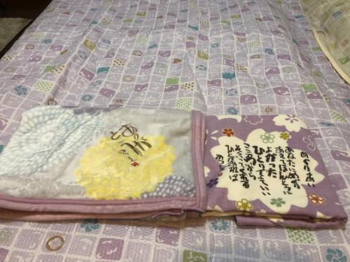 a book with hello kitty on it sitting on a bed at Guesthouse Yui in Hongu