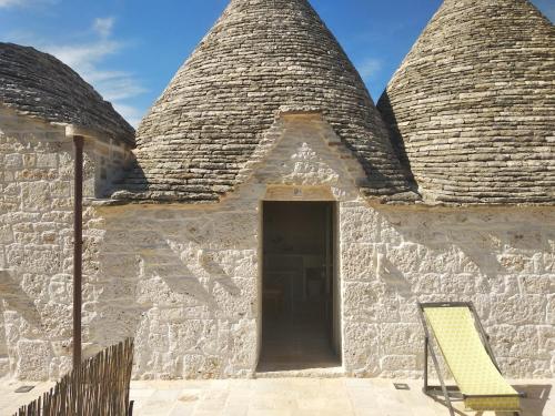 a building with two towers with a yellow bench at Le Dieci Porte in Alberobello