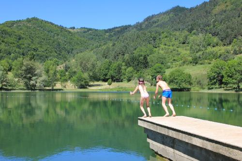 a couple of people standing on a dock in the water at Le Silence du Midi in Comus