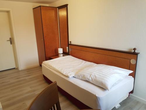 a bedroom with a bed with a wooden headboard at Gasthof zur Alten Post in Wimmelburg