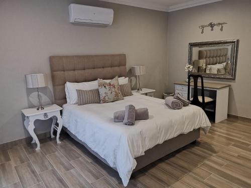 um quarto com uma cama grande e um espelho em Bella Rosa em Potchefstroom
