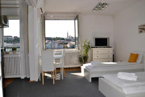 a white room with a bed and a tv and a window at Apartment Castle View in Budapest