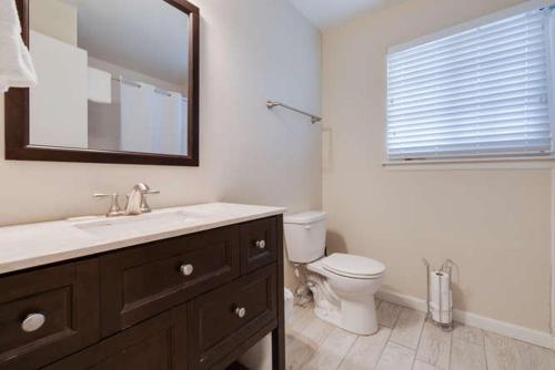 bagno con lavandino, servizi igienici e specchio di Foxtail a Siesta Key