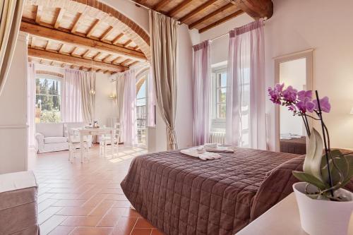ラストラ・ア・シーニャにあるResidenza Piandaccoliのベッドルーム1室(ベッド1台、紫の花のテーブル付)