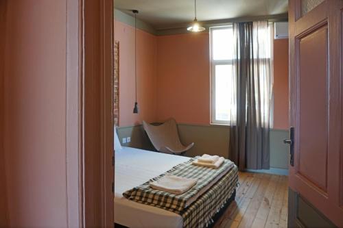 um quarto com uma cama, uma janela e uma cadeira em Beautiful best location apartment Red Mouse em Plovdiv