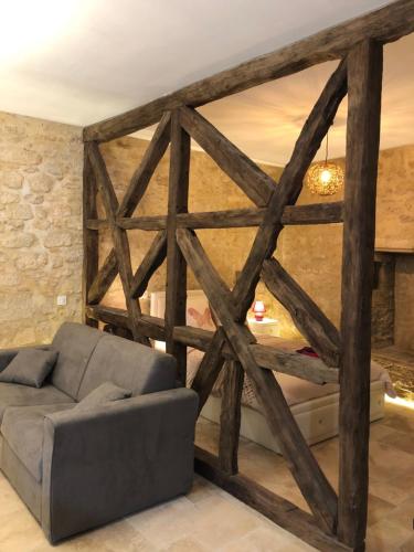 a living room with a couch and a stone wall at Les Arcades in Sarlat-la-Canéda