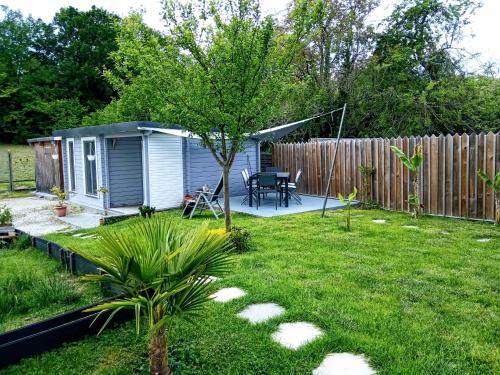 einen Hinterhof mit einem winzigen Haus und einem Zaun in der Unterkunft AGREABLE PETIT CHALET in Camarsac