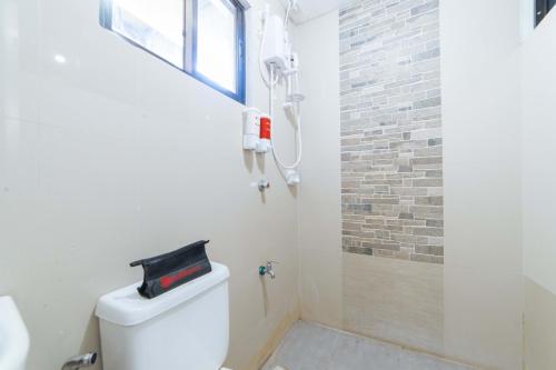 a bathroom with a shower and a white toilet at RedDoorz @ Aparente Gensan in General Santos