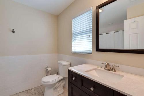 ein Badezimmer mit einem WC, einem Waschbecken und einem Spiegel in der Unterkunft Bayberry in Siesta Key