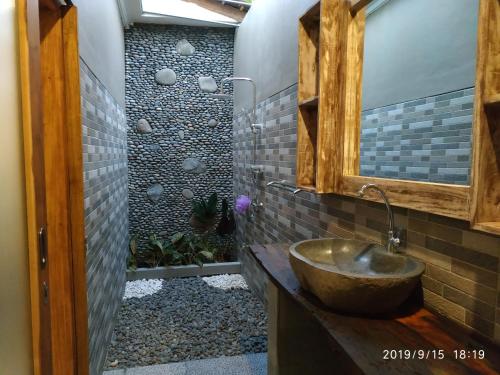 y baño con lavabo y espejo. en Harris surf villa, en Pulukan