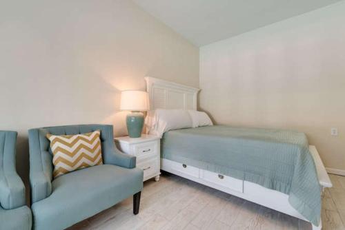 a bedroom with a bed and a couch and a chair at Whitewood in Siesta Key