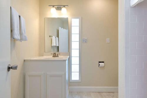 a white bathroom with a sink and a mirror at Whitewood in Siesta Key