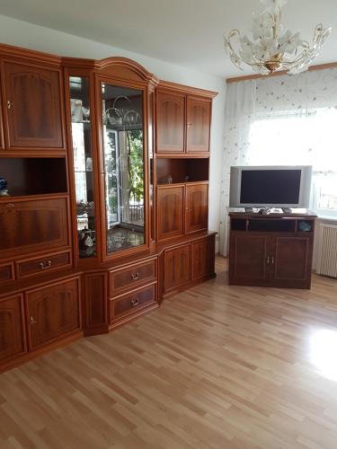 a large living room with wooden cabinets and a television at Ferienwohnung Schamne in Wutöschingen