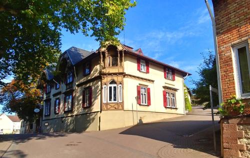 an old building with red windows on a street at Privathotel Der Schwarze Herrgott No TV in Zellertal