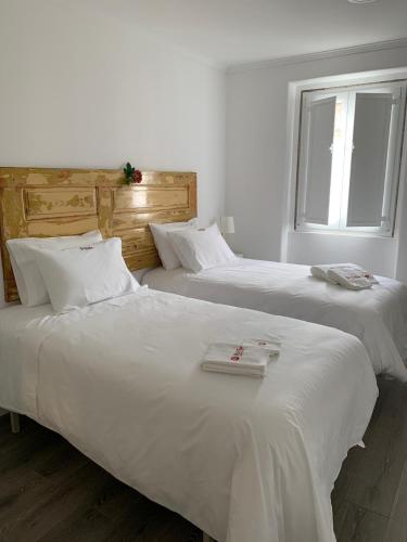 two white beds in a room with a window at Alter Village Apartments in Alter do Chão