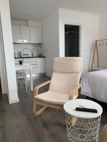 a room with a chair and a table and a kitchen at Alter Village Apartments in Alter do Chão