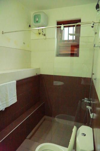 a bathroom with a toilet and a glass shower at Villa 61 in Ambepussa