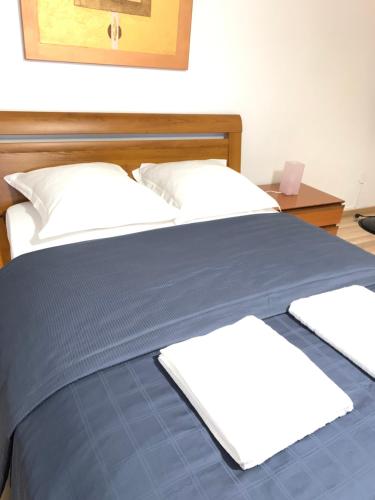 a bed with a blue blanket and white pillows at Aux deux hirondelles in Houssen