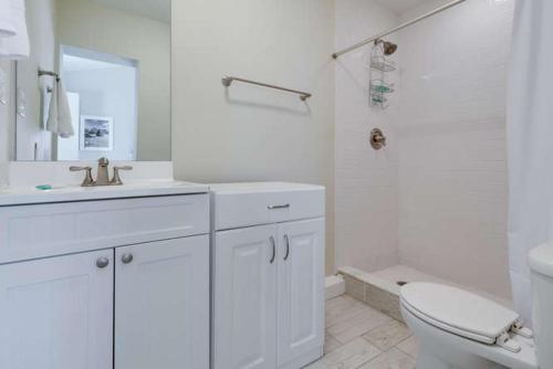 a white bathroom with a toilet and a sink at Wild Plum in Siesta Key