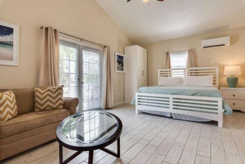 um quarto com uma cama, um sofá e uma mesa de vidro em Wild Plum em Siesta Key