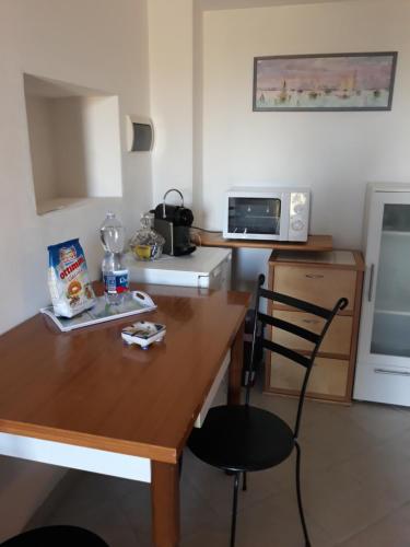 una pequeña cocina con mesa de madera y microondas en Agriturismo I Due Pini, en Magliano in Toscana