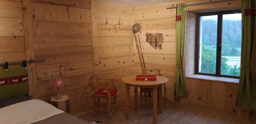 a room with a small table in a log cabin at Le Jura en toutes saisons Piscine, SPA, location VTT, balades 2cv, climatisation in Bonlieu