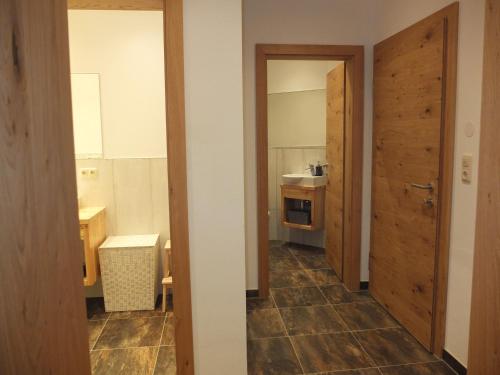 a room with a kitchen with a door and a bathroom at Apartment Haus Dahoam in Alpbach