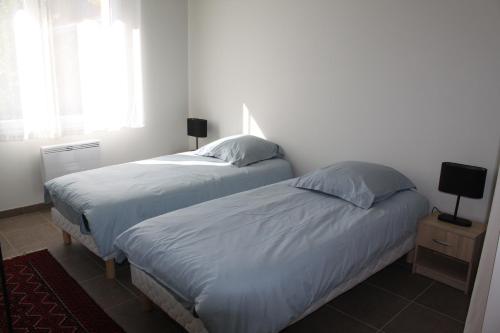 - 2 lits dans une chambre blanche avec fenêtre dans l'établissement Villa Caramel, à Saint-Quentin-la-Poterie