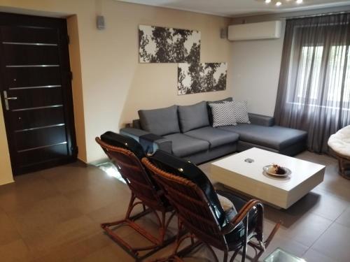 a living room with a couch and a table and chairs at Modern Residence in the Center of Trikala in Tríkala