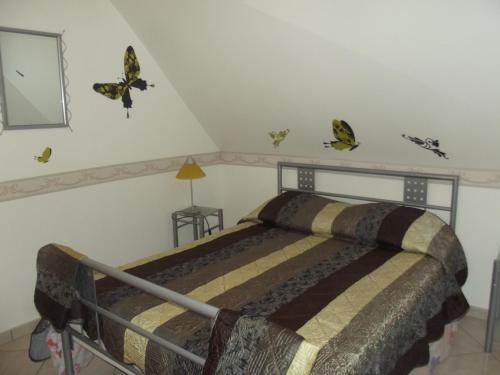 um quarto com uma cama com borboletas na parede em APPARTEMENT WISSANT em Wissant