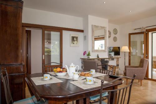 uma cozinha e sala de jantar com mesa e cadeiras em Carrasqueta em Port d'Alcudia