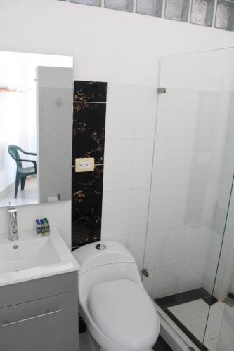 a bathroom with a white toilet and a sink at ATENEA SPA Hotel in Villeta