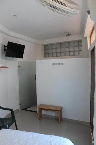 a room with a bed and a table and a tv at ATENEA SPA Hotel in Villeta