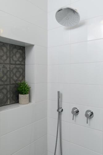 a bathroom with a shower with a plant in it at The Rambam Residence - By Localz Group in Tel Aviv
