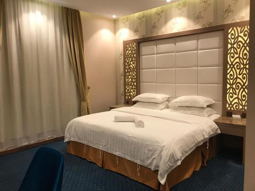 Un pat sau paturi într-o cameră la Ajwaa Suites