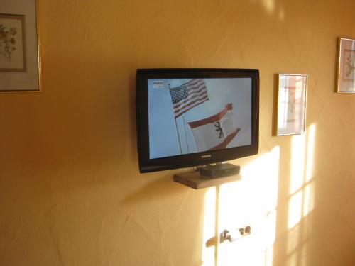 a flat screen tv on a wall with an american flag at ST Michael Atrona GmbH in Euskirchen