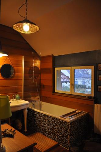une salle de bain avec une baignoire et un lavabo dans l'établissement Villa le Cloky, à Thomery
