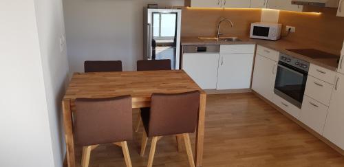 a small kitchen with a wooden table and chairs at Ferienwohnung Modi in Gamlitz