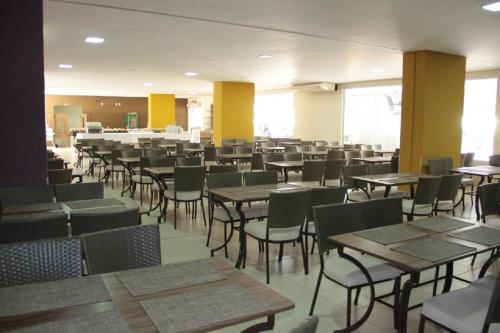 une salle à manger avec des tables et des chaises dans un bâtiment dans l'établissement Veredas do Rio Quente - FR Turismo, à Rio Quente