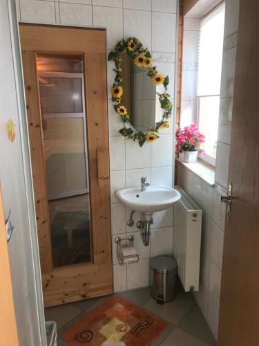 Ferienwohnung Hoppelnase mit eigener Sauna في Langenstein: حمام مع حوض ومرآة
