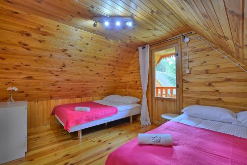 1 dormitorio con 2 camas en una cabaña de madera en Bieszczady Resort, en Polańczyk